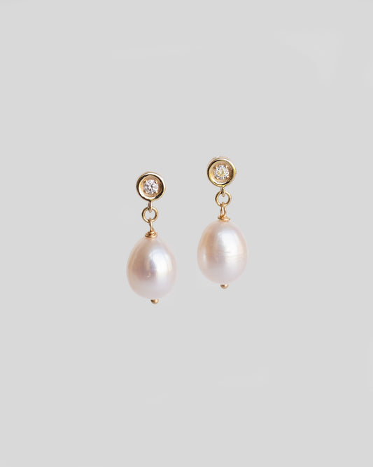 pair of gold dangle earrings with diamonds and white pearls