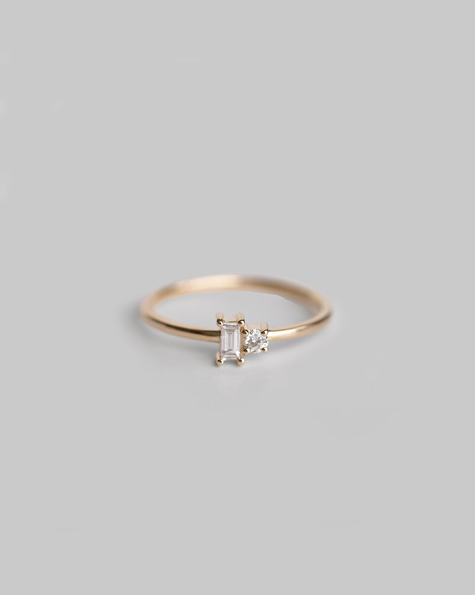 delicate gold ring with baguette and round diamond