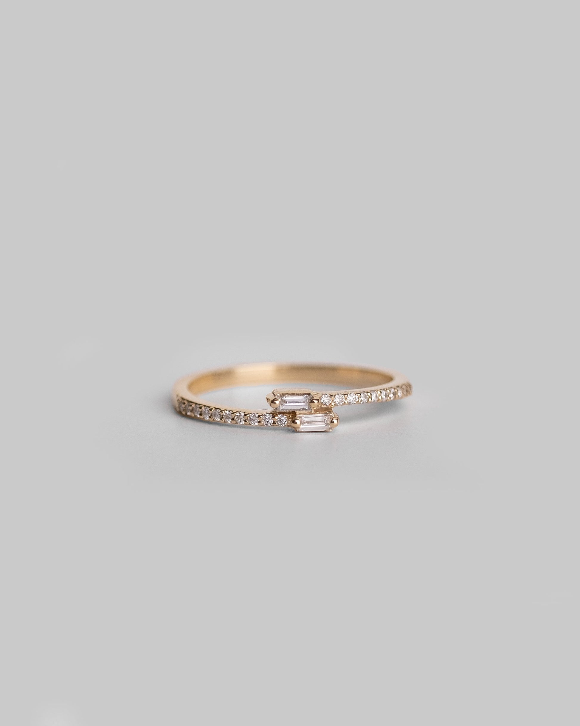 gold delicate ring with round diamond pave band and two crossover baguette diamonds 