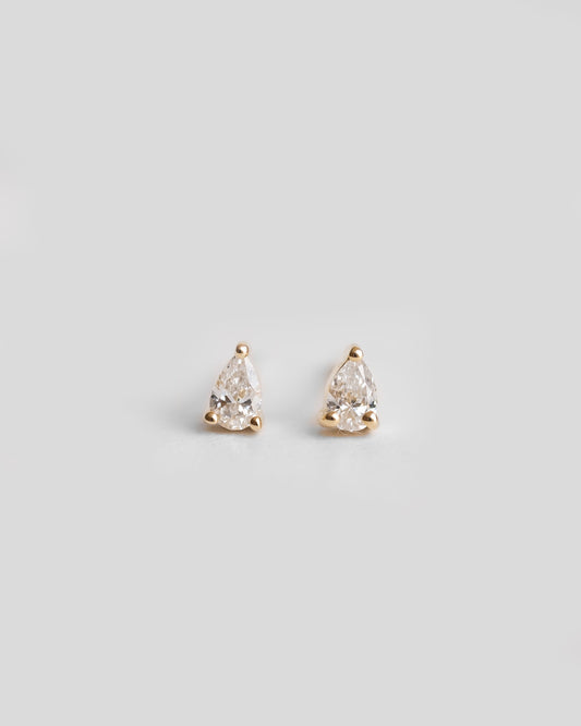 a pair of gold earrings with a single diamond