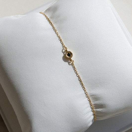 gold chain with small single black diamond