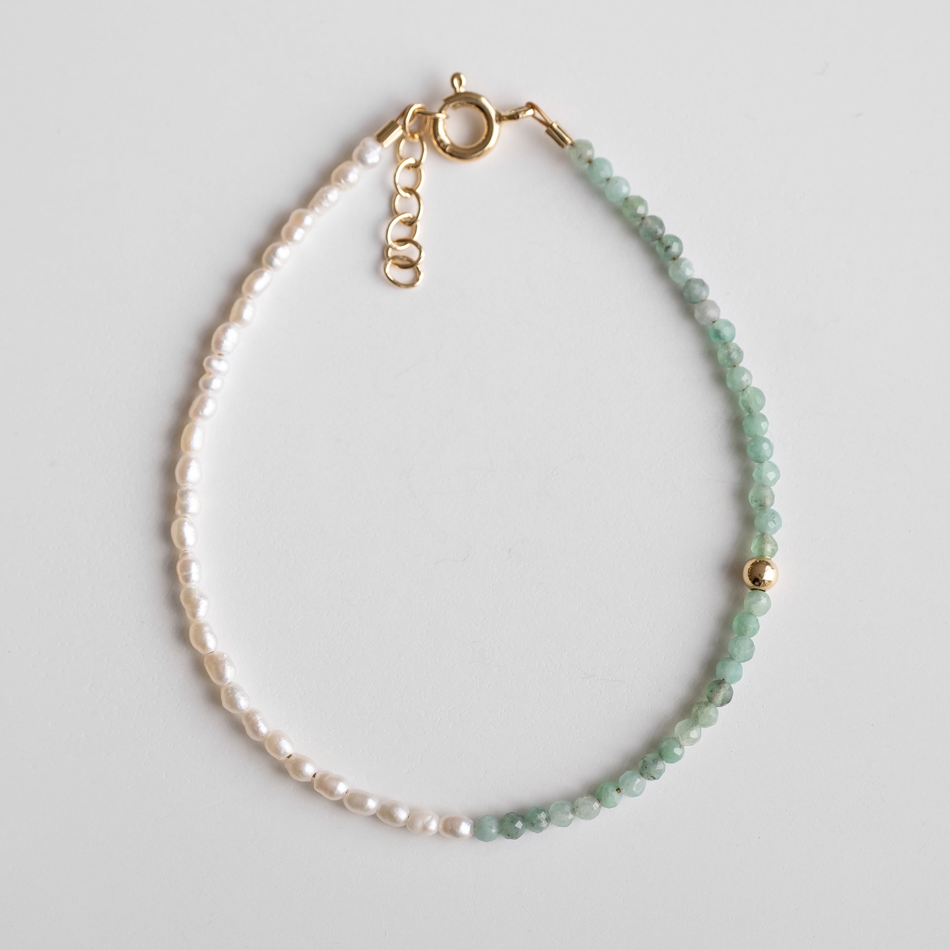 deicate gold bracelet with pearls and emerald 